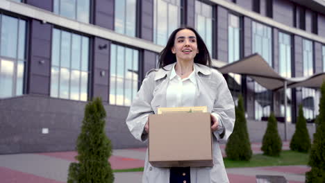una mujer bonita camina frente a un edificio de oficinas