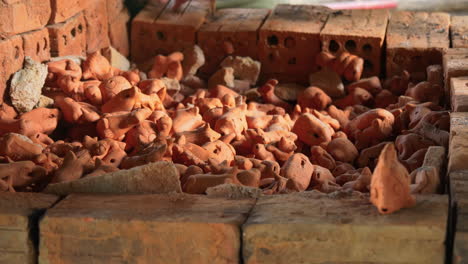 tight side view of hands removing southeast asian clay animal figurines from kiln, than ha hoi an vietnam