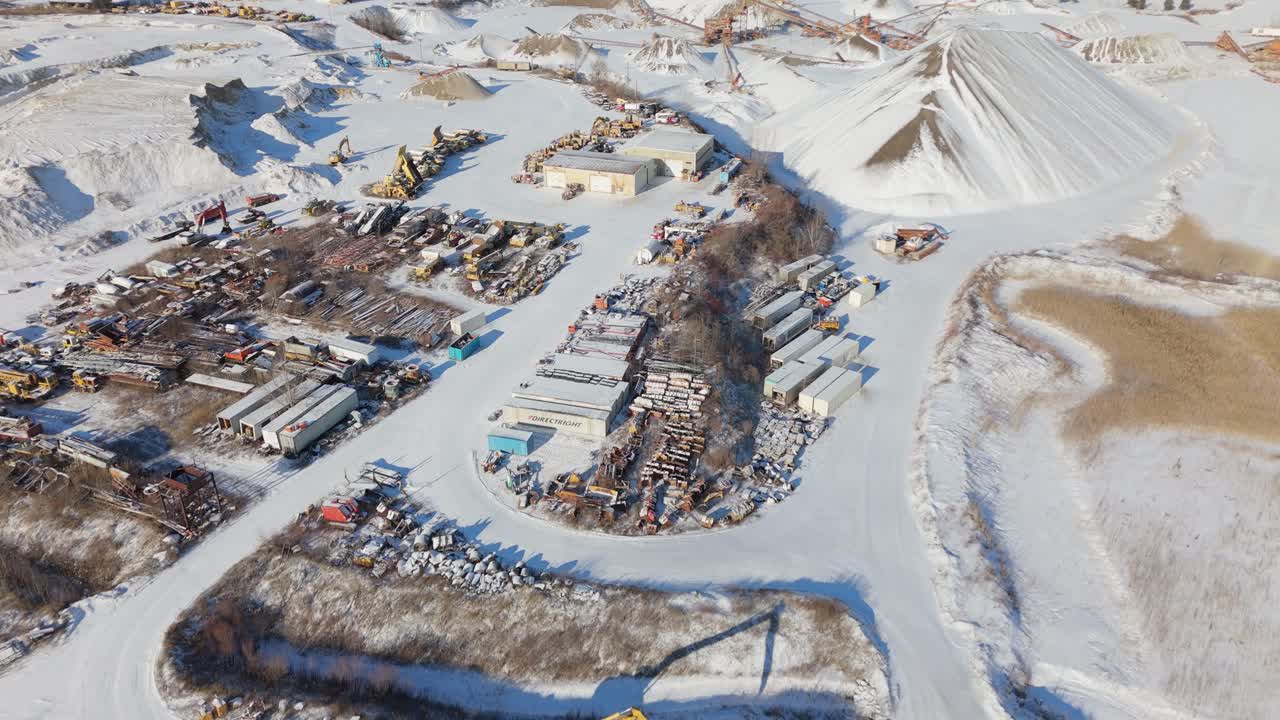 промышленная площадка по гравийной яме в заснеженном канадском ландшафте, с воздуха