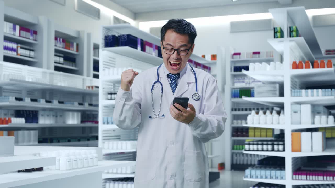 스마트폰을 사용하고 약국에 서서 성공을 축하하는 스테토스코프를 가진 아시아 남성 의사