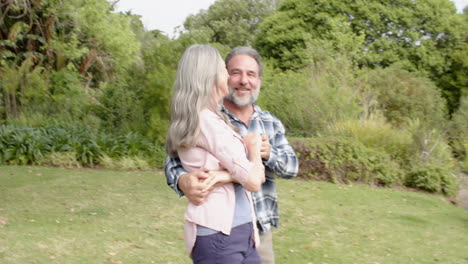 happy mature couple embracing outdoors, enjoying joyful moment in nature