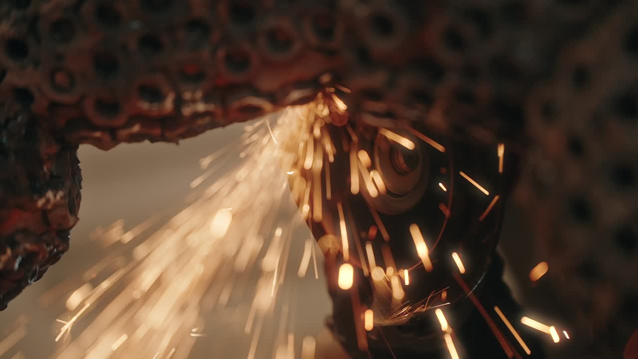 close up of bright sparks flying from angle grinder cutting metal in slow motion