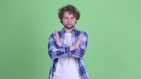 un joven guapo, barbudo y hipster con el cabello rizado.