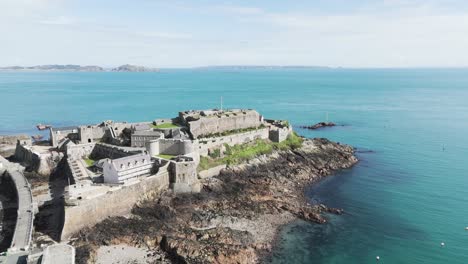 castillo cornet, vuelo en un día despejado y soleado, castillo histórico en st peter port guernsey con mar tranquilo y claro y vistas sobre jethou, herm y sark