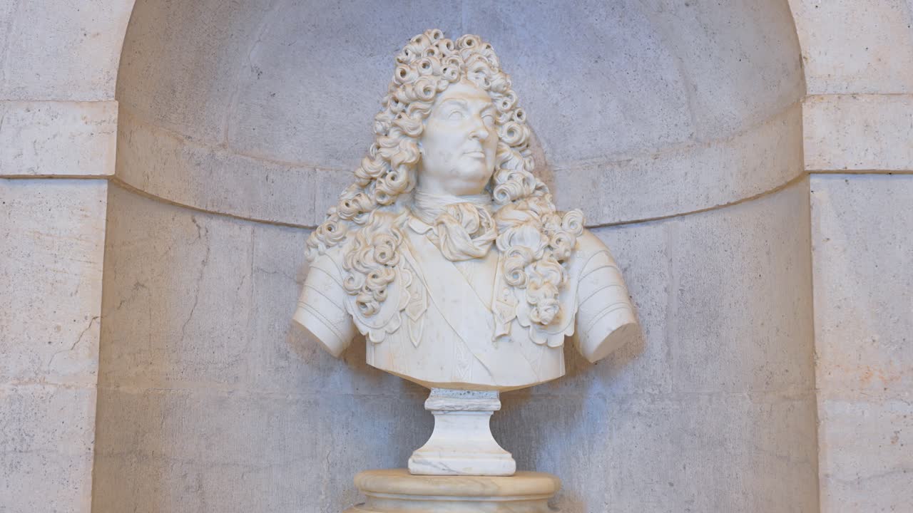 Baroque bust depicting King Louis XIV, displayed at Aranjuez Royal Palace entrance, showcasing opulent European royal portraiture and historical artistry in Spain.