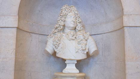 baroque bust depicting king louis xiv, displayed at aranjuez royal palace entrance, showcasing opulent european royal portraiture and historical artistry in spain.
