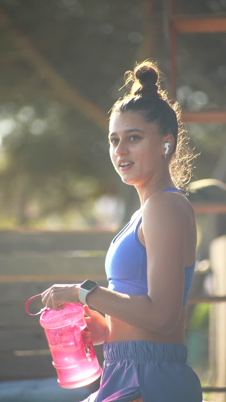 Woman in activewear with water bottle outdoors
