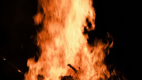 big bonfire burns at night on a black background