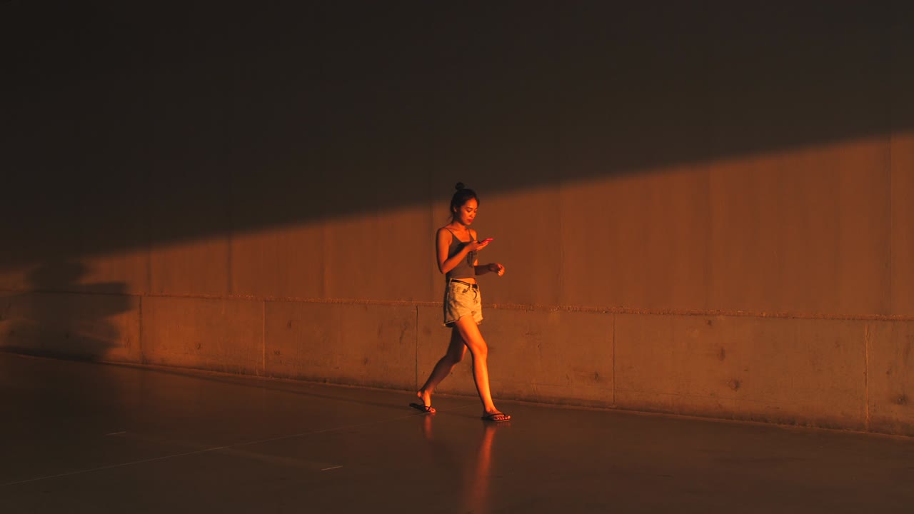 Mulher bonita usando o telefone caminhando, 4K