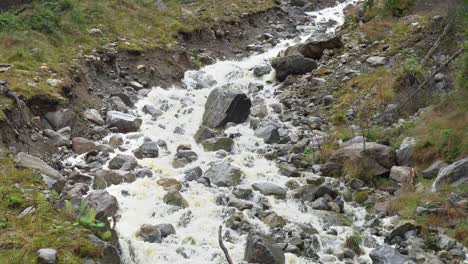 una pequeña corriente de exceso de agua de lluvia excava un nuevo canal en la ladera de una colina en noruega