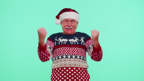 Grandfather-man-in-sweater-Christmas-Santa-shouting,-celebrating-success,-winning,-goal-achievemen