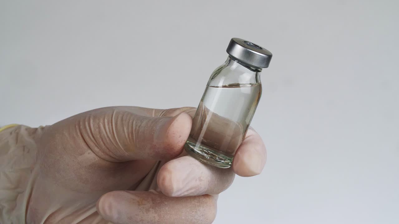 Medical Vial in Gloved Hand