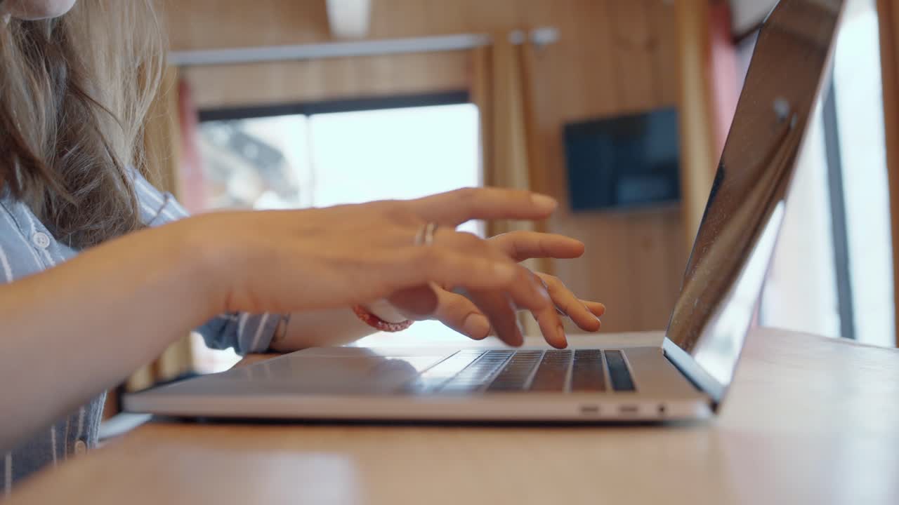 Dynamic wide angle view of woman working on laptop, representing productivity, modern environment.