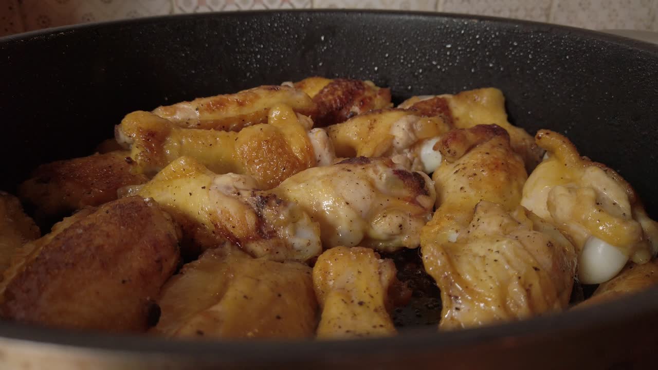 piel y carne de pollo en hueso cocinando lentamente en sartén caliente
