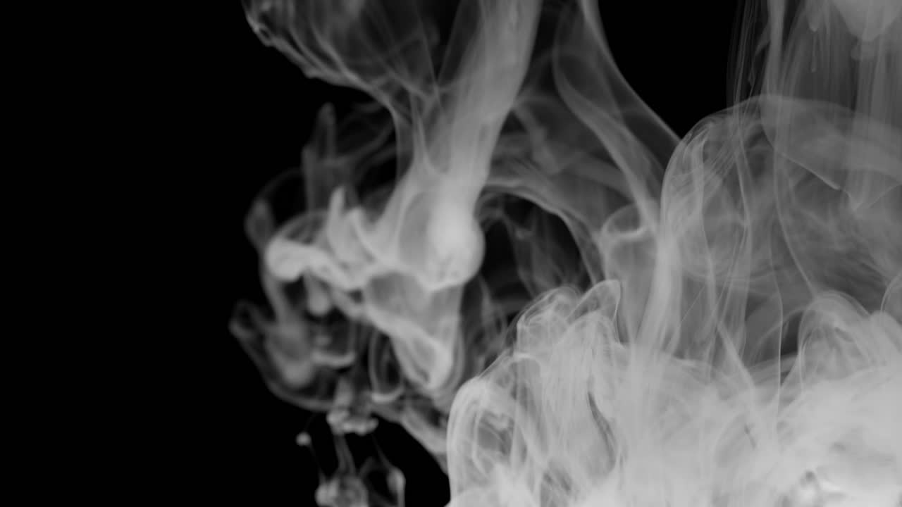 Due nuvole di fumo bianche e luminose riempiono il lato destro di un'inquadratura nera
