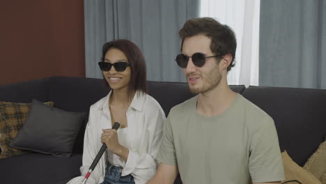 Close-up-view-of-blind-friends-sitting-on-a-sofa-in-a-flat