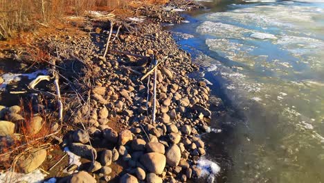 Felsige-Küste-Und-Ein-Fluss,-Entlang-Dem-Eis-In-Jakutien-Schwimmt-4k-Von-Einer-Drohne