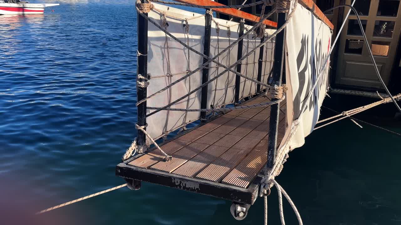 Wooden entry deck with ropes for an old boat, Greece, close up view