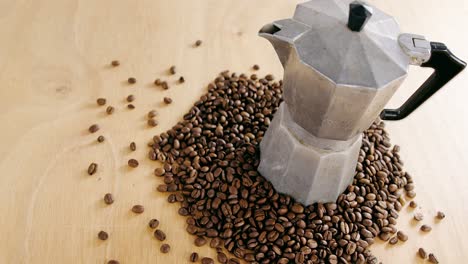granos de café con cafetera metálica