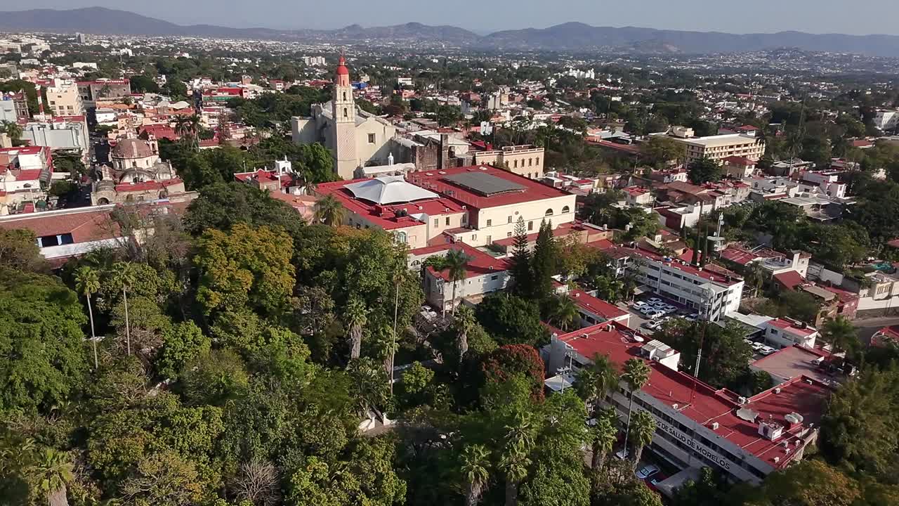 Cuernavaca with lush greenery, colonial architecture, and a church tower , aerial view