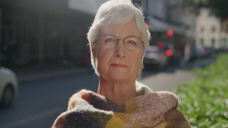 retrato de una hermosa anciana que busca la calma pensativa en la cámara con una bufanda de mediana edad caucásica edad de jubilación femenina en el fondo de la ciudad urbana