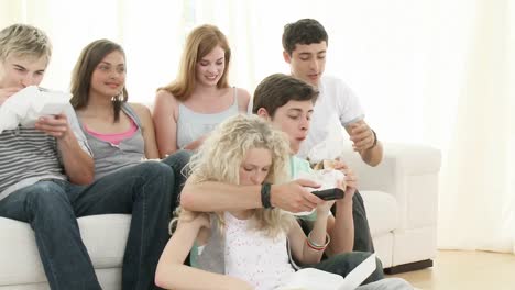 panorama de adolescentes viendo televisión y comiendo sándwiches
