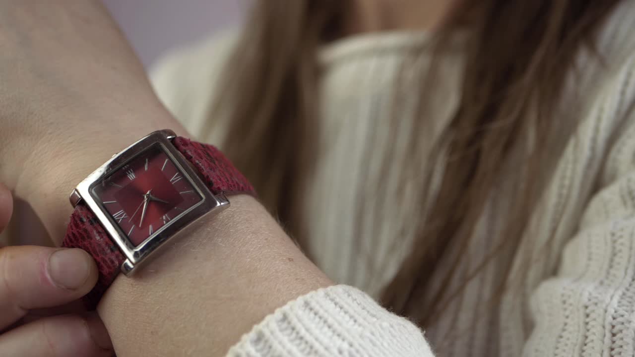 mano frotando la muñeca después de mirar el primer plano del reloj