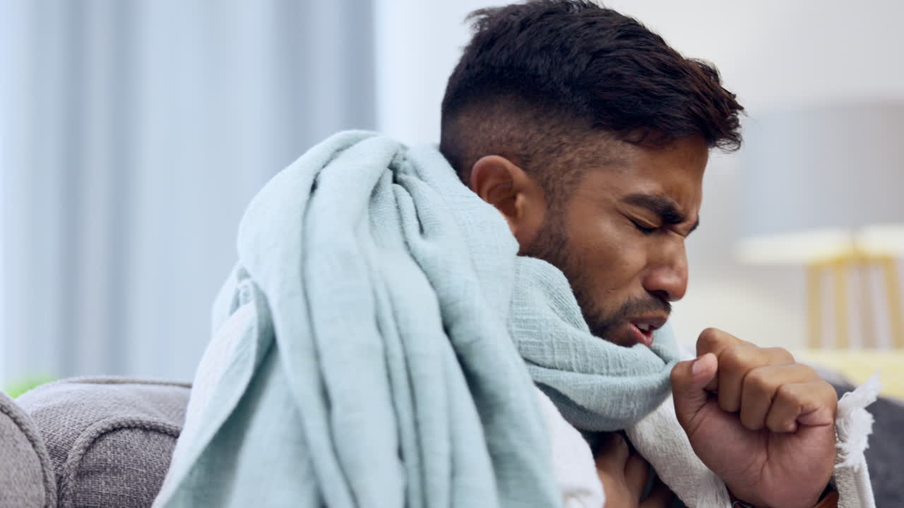 Sick, cough and healthcare with Indian man on sofa