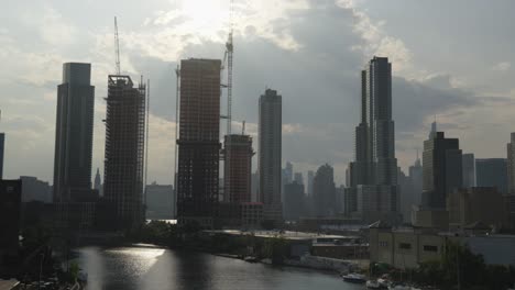 En-Una-Escena-Al-Final-De-La-Tarde,-Un-Lapso-De-Tiempo-Muestra-Un-Grupo-De-Nubes-A-La-Deriva-Detrás-Del-Horizonte-Lleno-De-Construcción-De-Manhattan