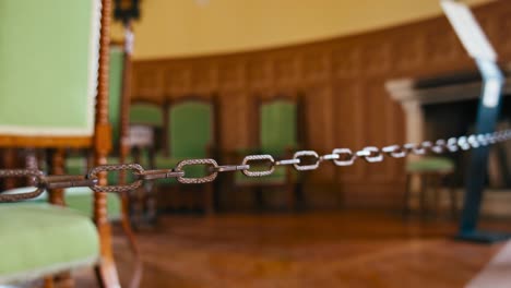 decorative barrier chain inside trakošćan castle's hunting hall with a backdrop of ornate furniture