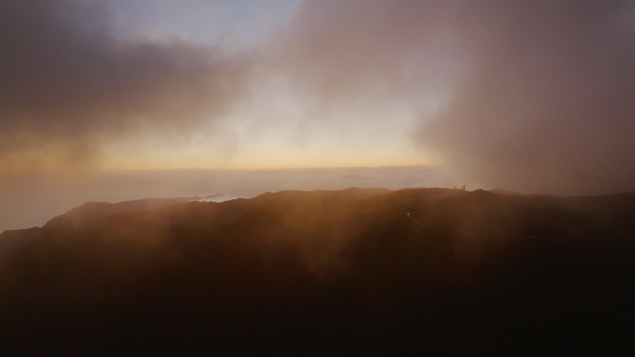temprano en la mañana antes del amanecer detrás de las nubes sobre las montañas y el océano