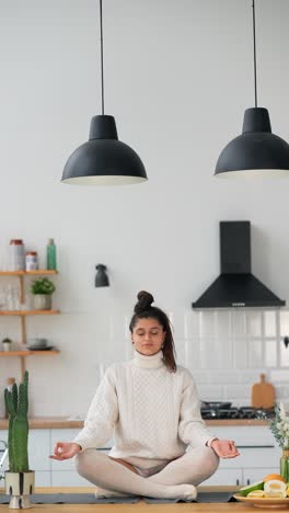 woman meditating in a kitchen