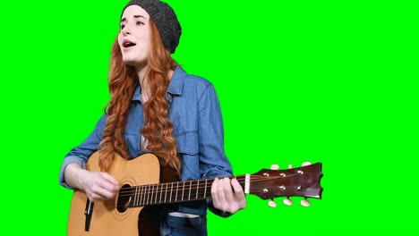 female musician singing while playing guitar