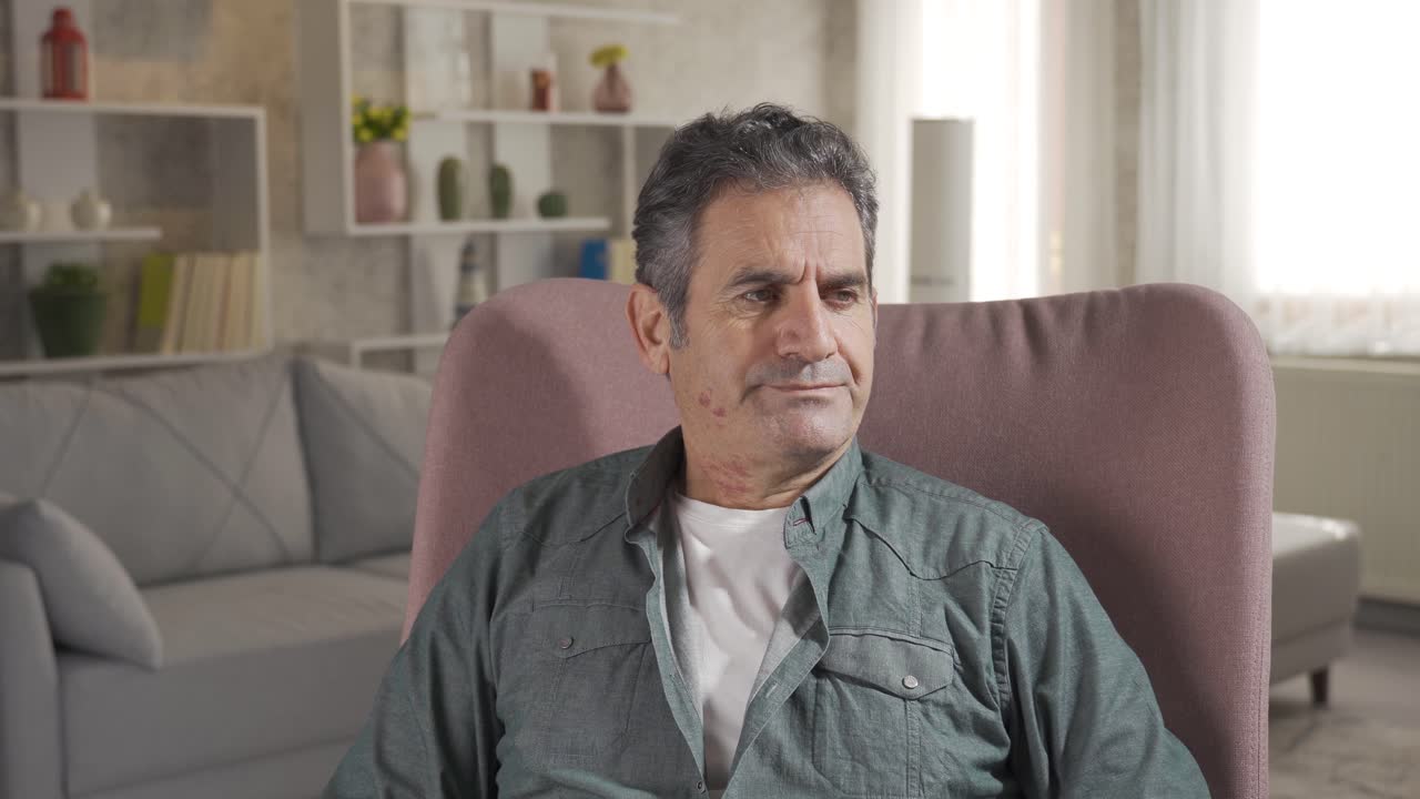 un hombre maduro y solitario sentado en el sofá de su casa. concepto de salud mental y depresión.