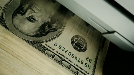 money being fed into a printer