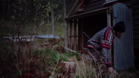 hombre europeo cortando leña con un hacha en trondelag, noruega