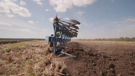 un tractor arando un campo agrícola seco, preparando la tierra para la siembra. industria agrícola. procesamiento del campo en la granja.
