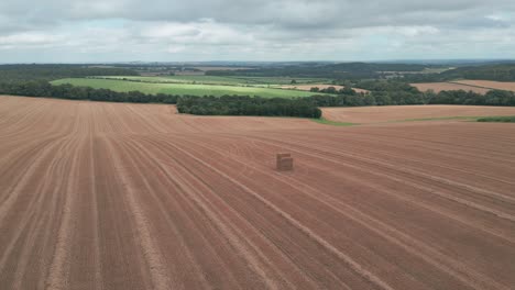 aerial panoramic overview of field lines below farley mount monument, winchester, uk, surrounded by harvested fields and natural greenery
