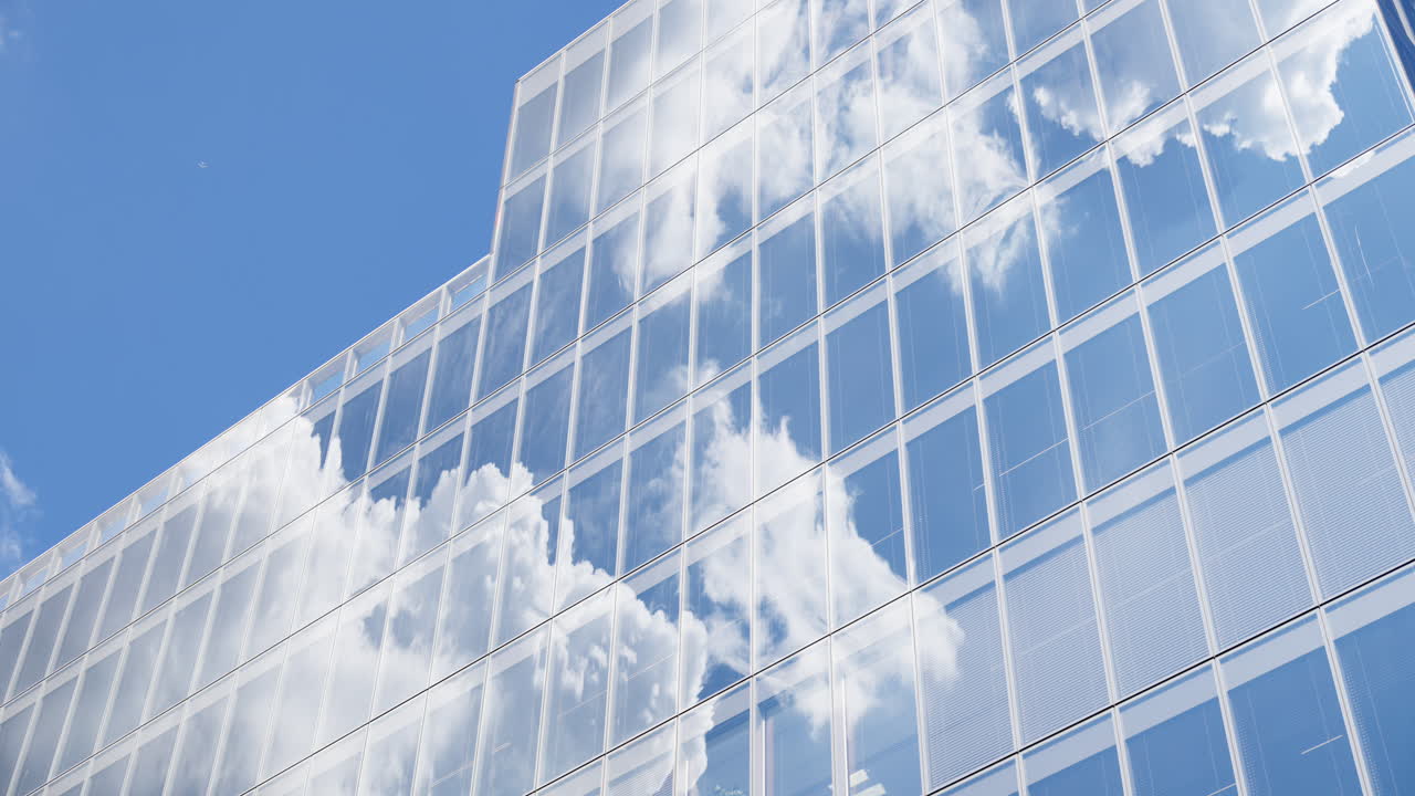 Modern glass skyscrapers of London's financial district reflecting the blue sky next to historic architecture
