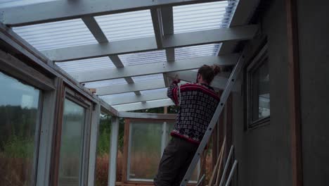 A-Man-is-Adding-Support-to-the-Roof-of-a-Greenhouse-in-Indre-Fosen,-Norway---Close-Up