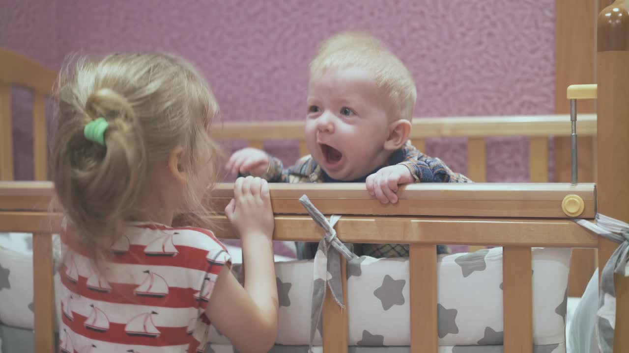 소녀는 어린이 방에서 동생과 함께 놀고 있는 침대에서 점프합니다.