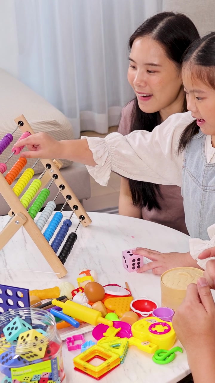 家族がサイコロとそろばんを使って遊びながら学ぶひとときを楽しみ、学習と絆を育んでいる。