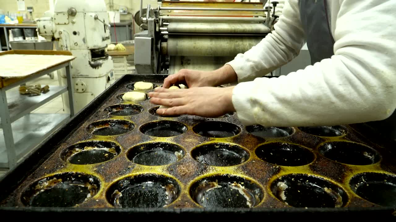 Baker lay out the dough buns on a baking tray