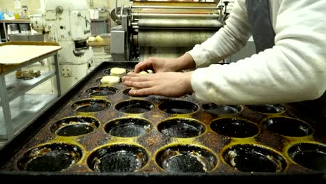 baker lay out the dough buns on a baking tray