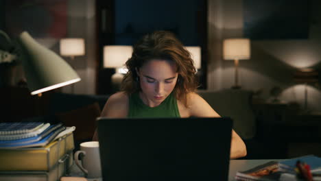 Mujer-Seria-Tomando-Notas-Primer-Plano-De-La-Casa-Por-La-Noche.-Chica-Involucrada-Mirando-Laptop