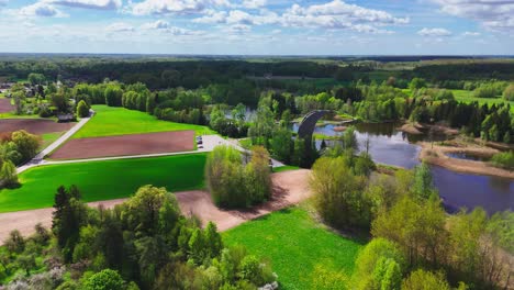 the kirkilai observation tower offers a breathtaking view of a stunning array of karst lakes, wetlands, and lush greenery within biržai regional park, lithuania - orbit drone shot