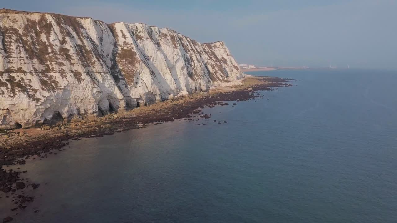 Drone flies low towards the White Cliffs of Dover with camera panning up