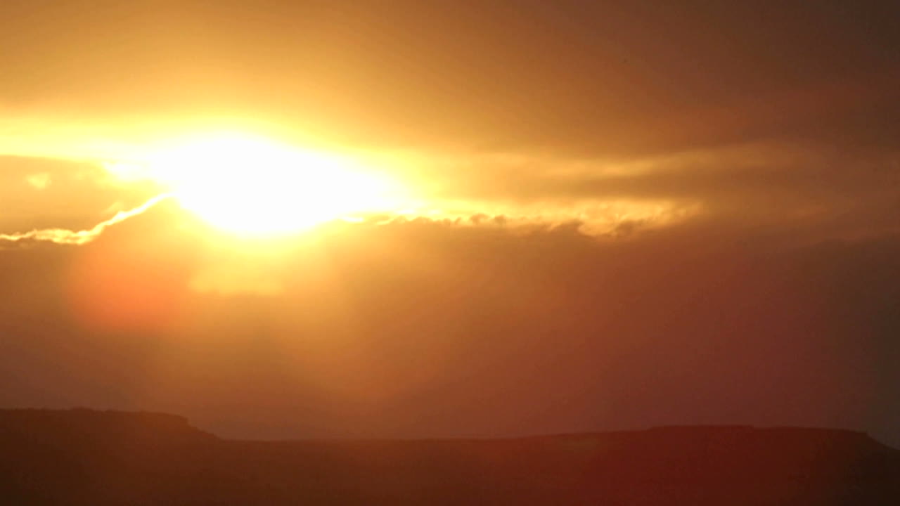 Die helle Sonne verschwindet hinter Wolken am sich verdunkelnden Himmel.