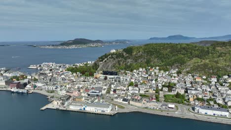 Antena-Panorámica-De-Verano-De-Alesund-Acercándose-A-La-Ciudad-Costera-Y-Al-Mirador-De-Aksla-Lentamente-Desde-La-Costa---Islas-Y-Océano-Atlántico-En-Segundo-Plano