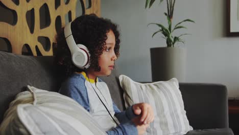 side view of caucasian boy with headset playing game on digital tablet in lobby at hospital 4k